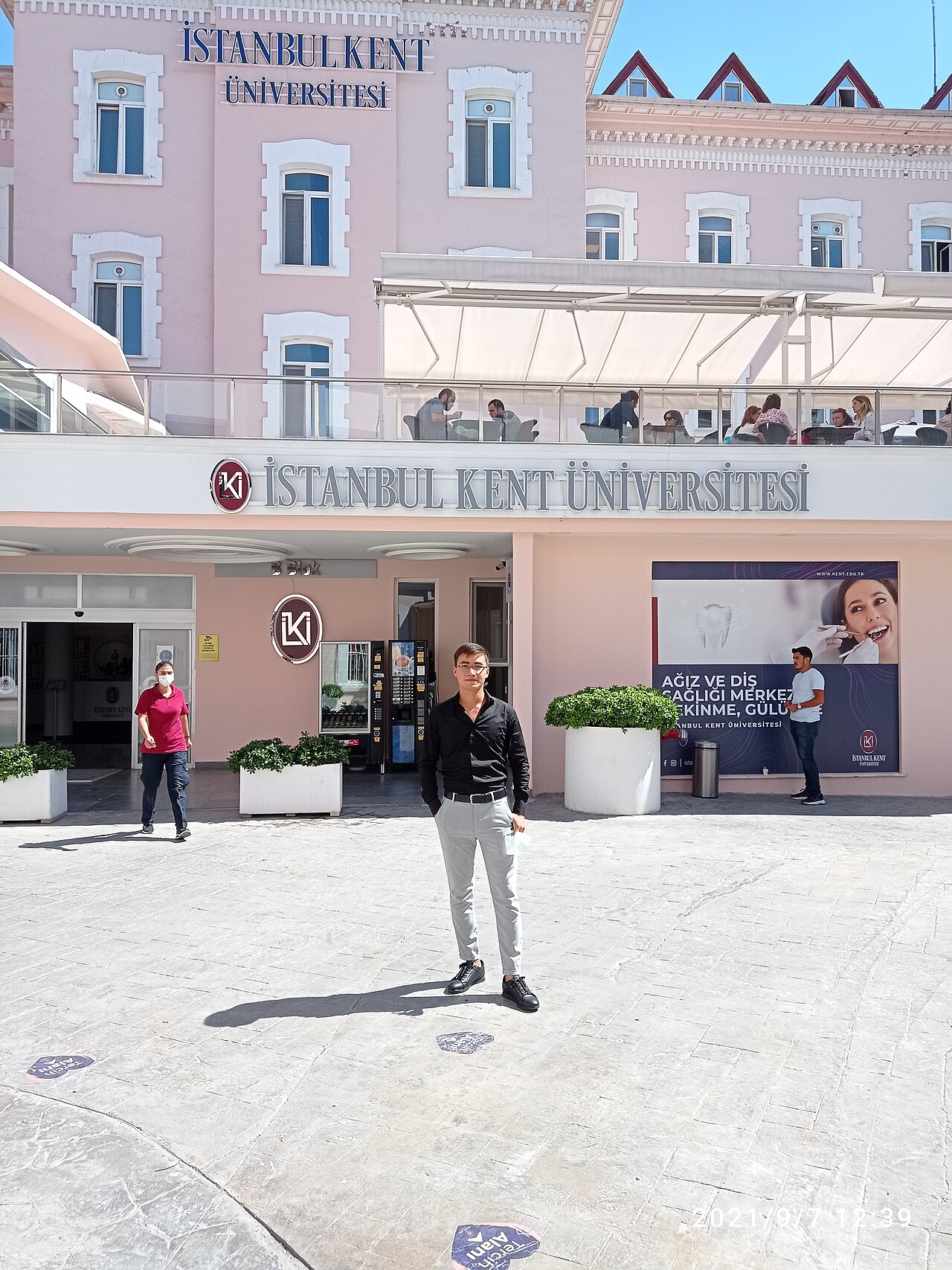 The courtyard entrance of Istanbul Kent University's historic pink campus building in Beyoğlu, signed "İSTANBUL KENT ÜNİVERSİTESİ".